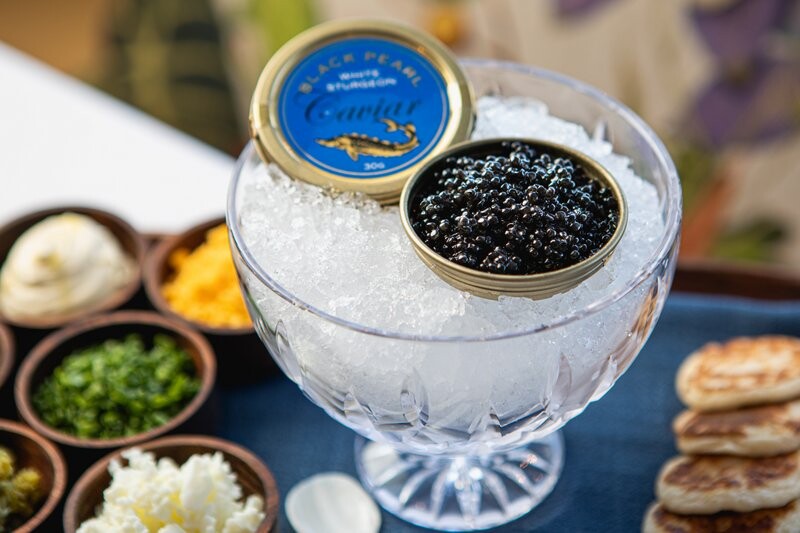 Tillerman Black Pearl White Sturgeon Caviar Served with Buttermilk Blini, Crème Fraiche, Chives, Cornichon, Egg White and Yolk IMAGE Judit Losh